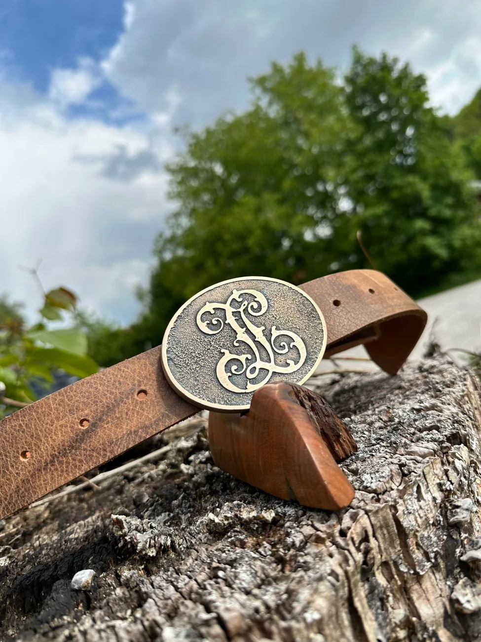 Ovale Gürtelschnalle mit verschlungenem Monogramm auf einem Ledergürtel