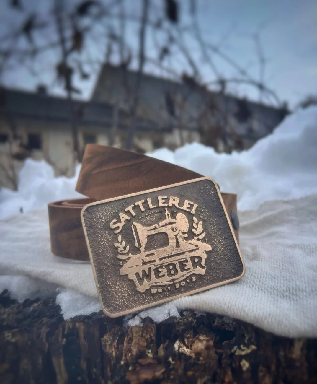 Gürtelschnalle mit Nähmaschinen-Motiv und Schriftzug einer Sattlerei