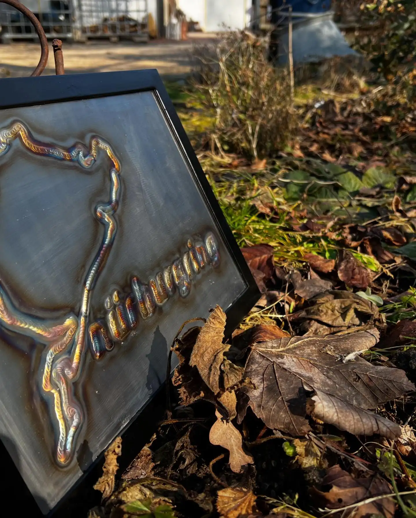 Gerahmtes Schweißbild einer Rennstrecke, angelehnt im Herbstlaub